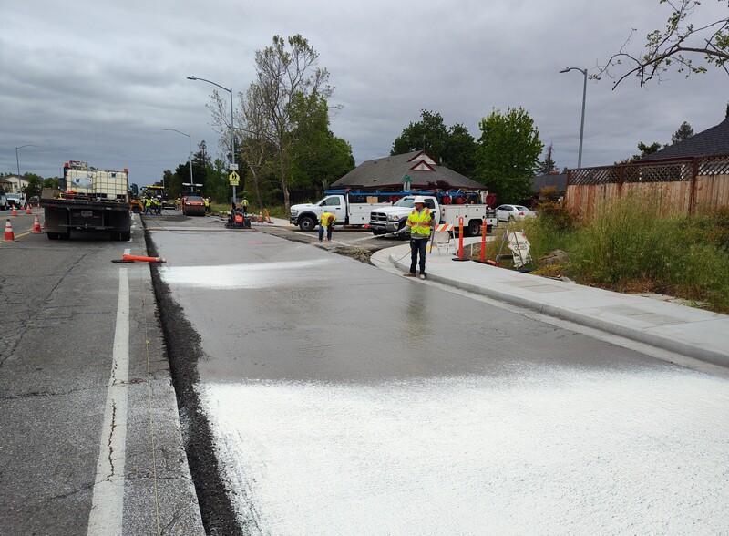 Applying a concrete curing resin to the road surface