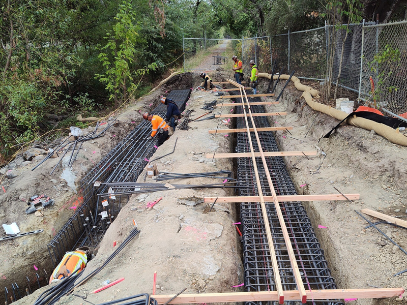 Tying rebar for the retaining wall foundations at the Forestview Creek Trail walking path