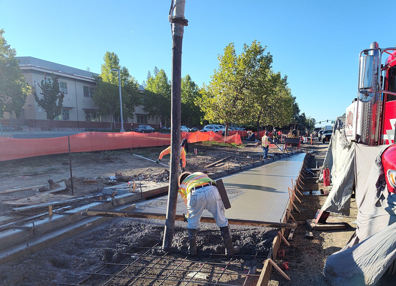 Pouring concrete for the new sidewalk in front of Piner High School
