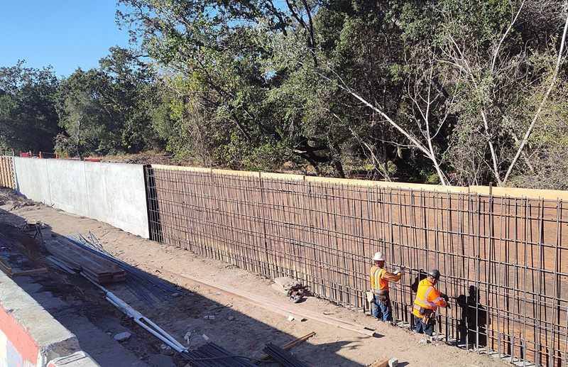 Amarrar barras de refuerzo para el nuevo muro de contención a lo largo del Parque Comunitario de la Juventud