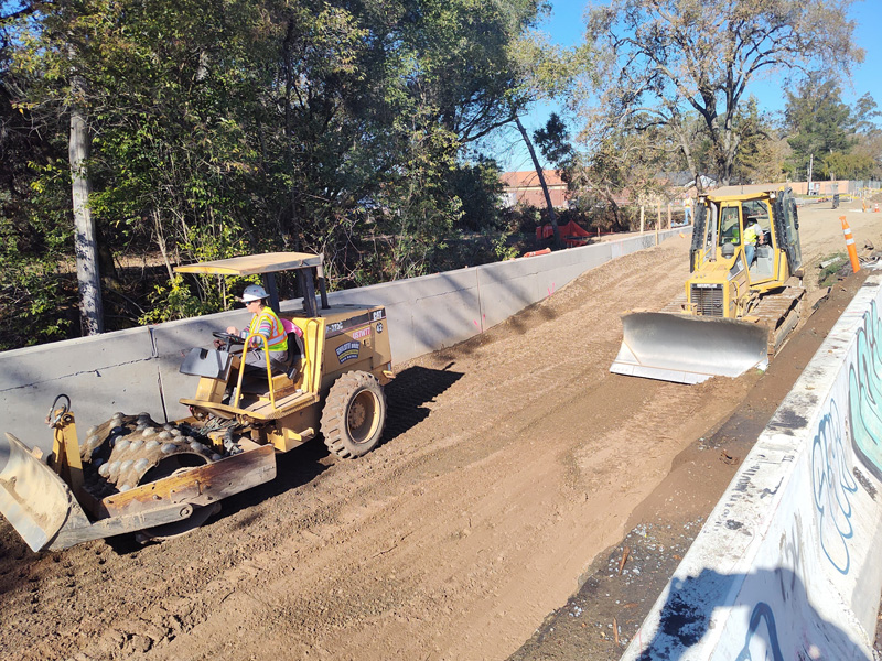 Placing and compacting fill for the road widening behind the new retaining wall